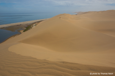 Hiking on big sand dunes at Sandwich Harbour in Namibia