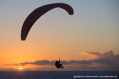 Paragliding flying over the ocean