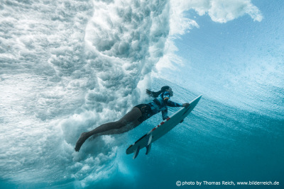 Surfer girl diving under water