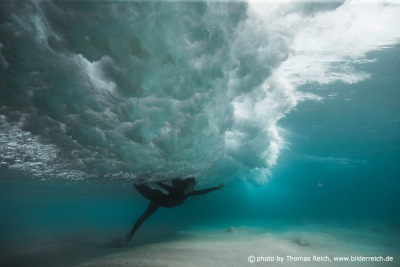 Underwater model posing under wave
