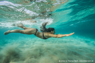 Woman swimming under water in the ocean