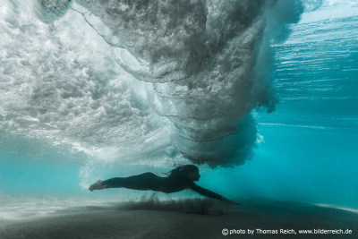 Woman under water beach wave