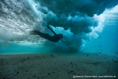 Unterwasseransicht Frau schwimmt unter Welle