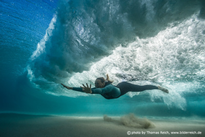 Woman swim underwater with Ocean wave